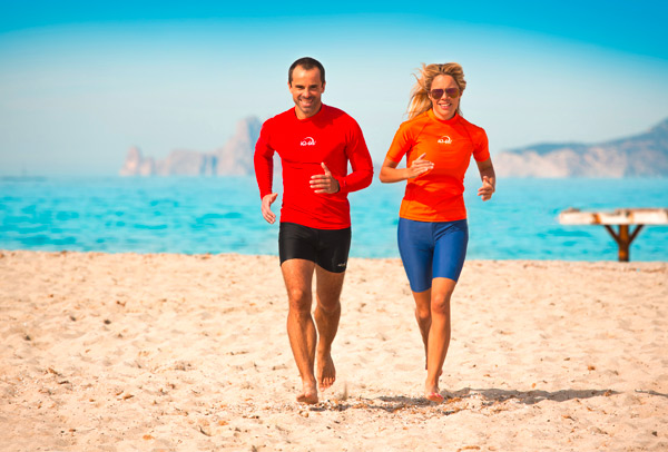 aktives Paar laufen am strand sonnenschutzkleidung